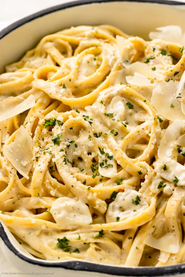 Angled, close-up photo of cooked pasta noodles tossed in a cream cheese pasta sauce.