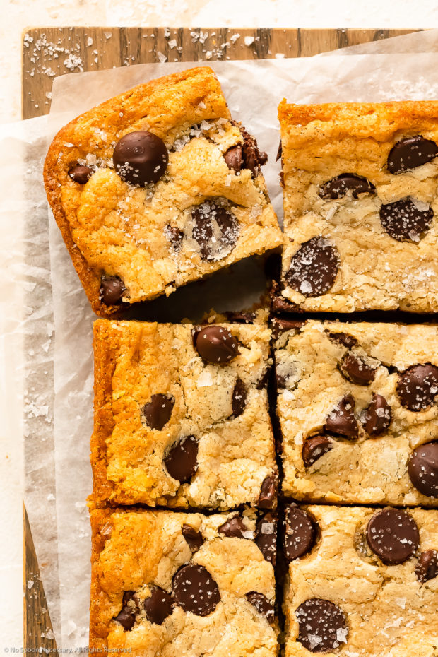 Overhead close-up photo a soft cookie bar with chocolate chips and flaky sea salt. 