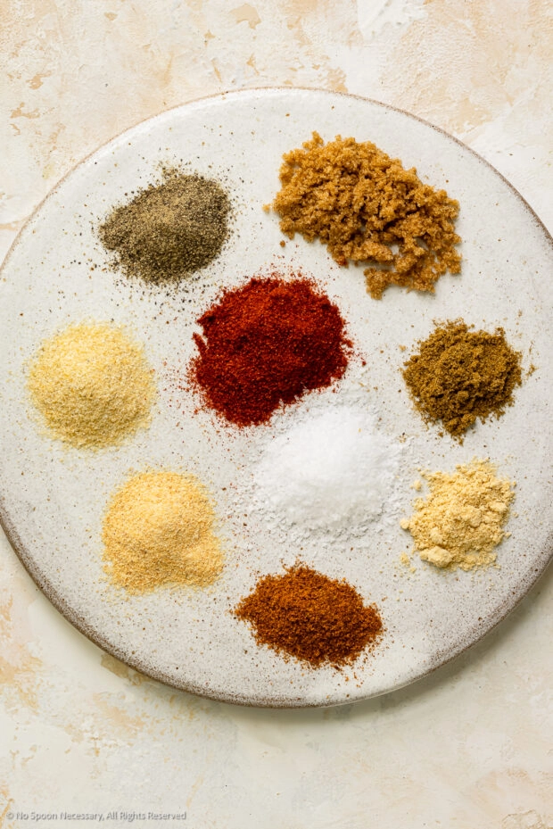 Overhead photo of the dry seasonings in homemade burger spices neatly organized on a plate.
