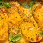 Overhead photo of four honey mustard chicken breasts in a baking dish.
