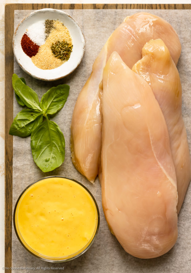 Overhead photo of the ingredients in mustard chicken recipe neatly arranged on a wood board.