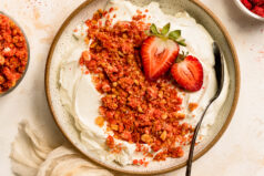 Overhead photo of a bowl of yogurt topped with strawberry crunch crumbles.