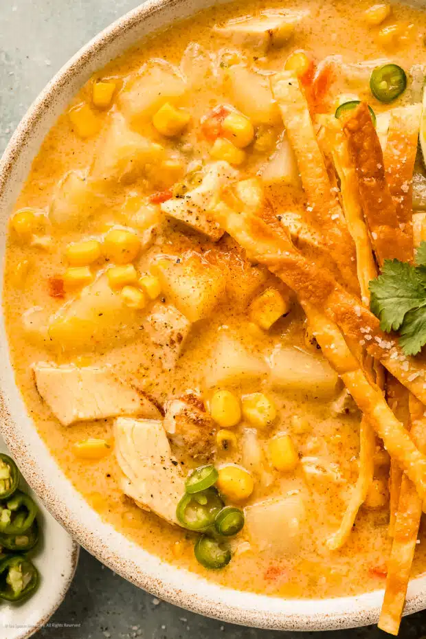 Close up photo of a bowl of corn chowder with chicken and potatoes.