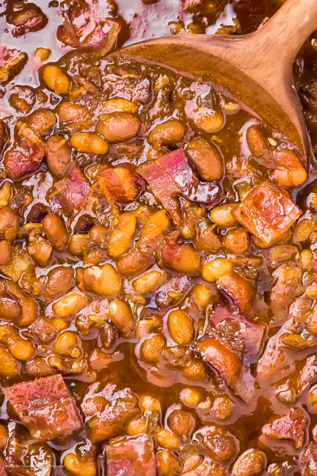 Overhead close-up photo of bacon baked beans with candied bacon, bourbon and brown sugar.