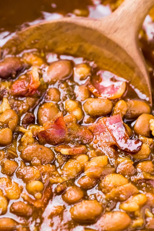 Close-up angled photo of baked bean recipe with bacon.