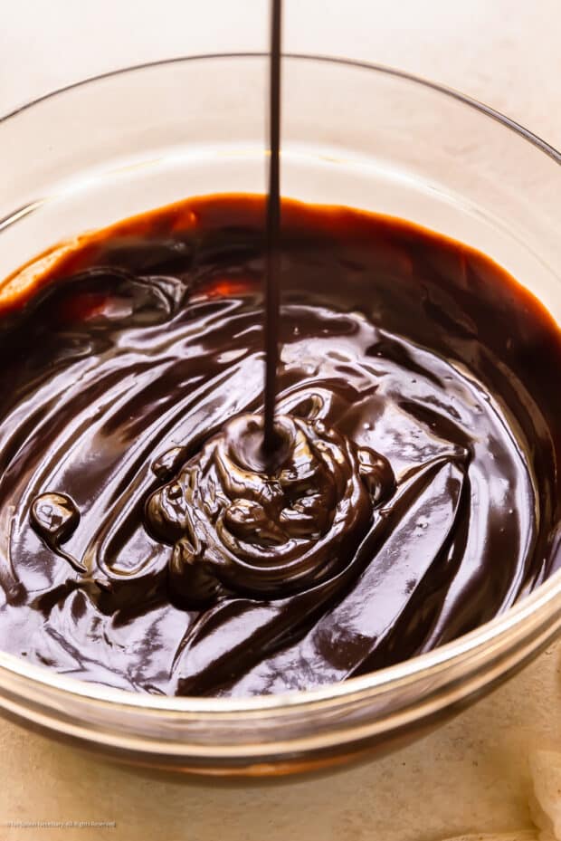 Action photo of chocolate dipping sauce being poured into a bowl.