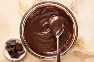 Overhead photo of dipping chocolate sauce in a bowl with a spoon.