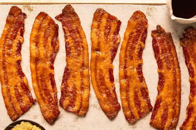Photo of six slices of candied bacon with maple syrup and brown sugar.