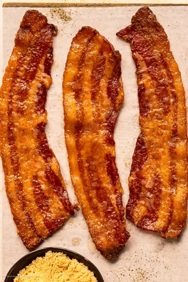 Photo of a crispy slice of candied maple bacon.