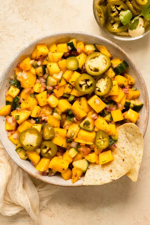Photo of tropical mango salsa topped with jalapeno pepper pickles.