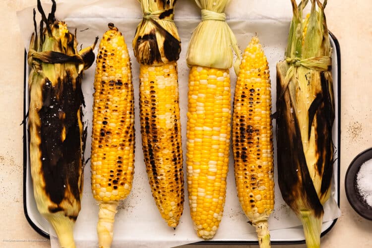 Overhead photo of six cobs of corn cooked on the grill three different ways.