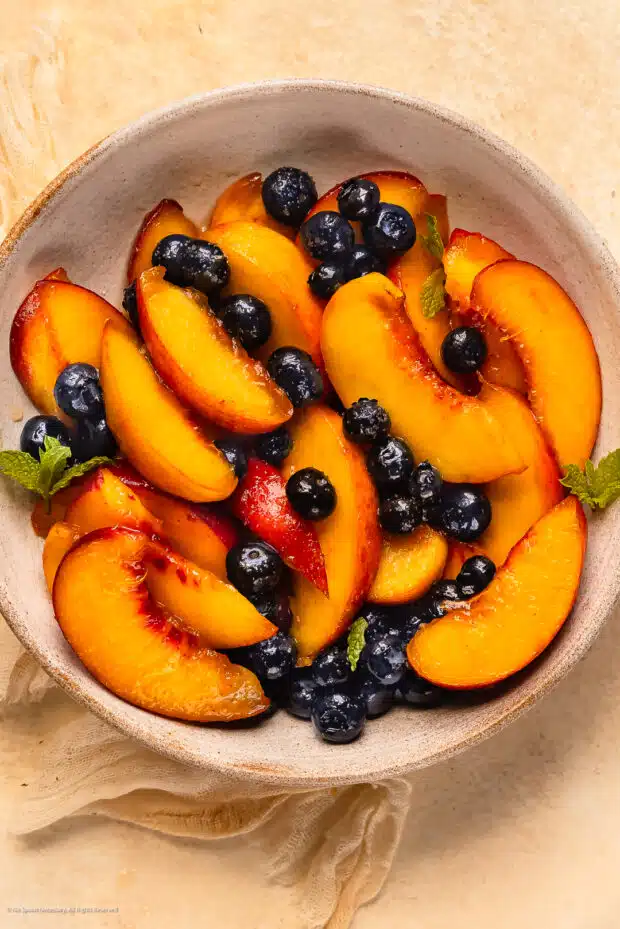Overhead photo of a bowl of fresh fruit macerated with sugar.