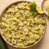 Overhead photo of zucchini rice side dish with parmesan and lemon zest in a serving bowl.