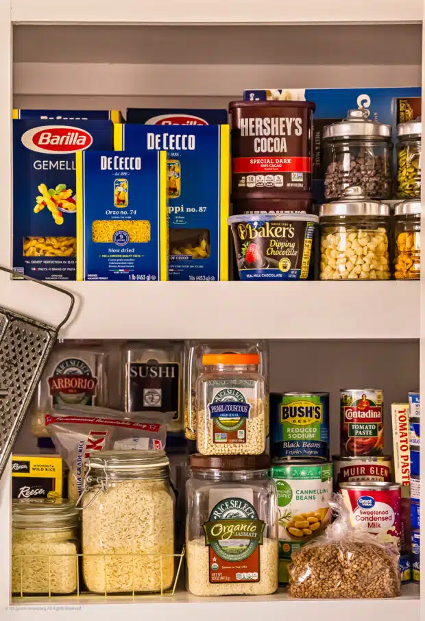 Straight on photo of food on two shelves in a stocked pantry.