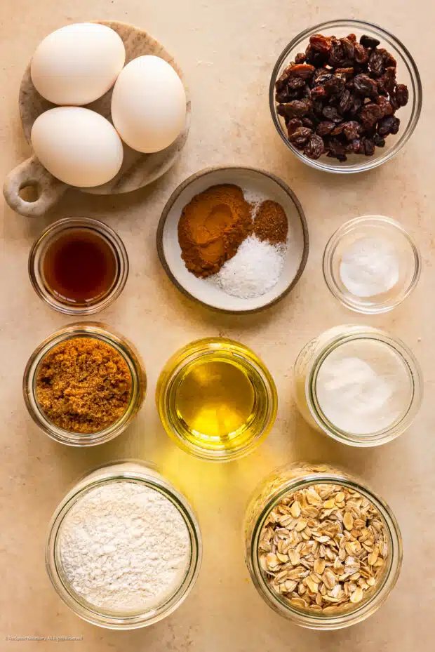 Overhead photo of the ten baking ingredients in the recipe for soft oatmeal cookies neatly arranged on a kitchen counter.