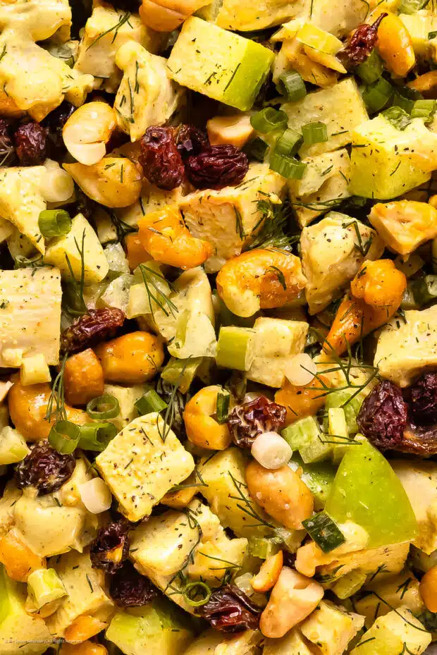 Close-up photo of chicken curry salad with cashews, green apples, and raisins.
