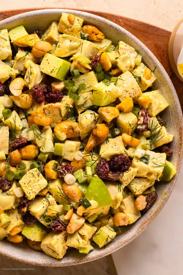 Overhead photo of a bowl of curry chicken salad with cashews.