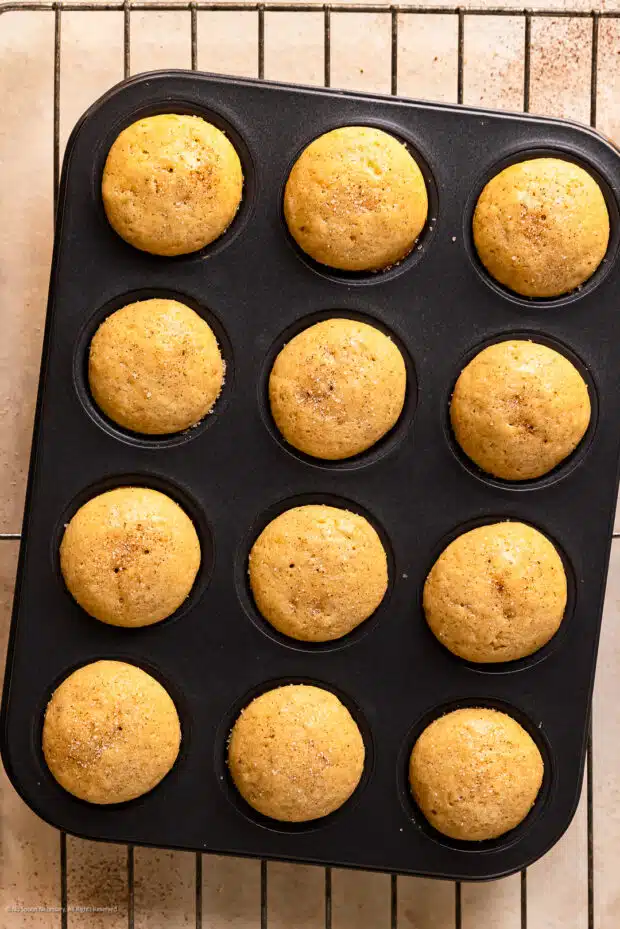 Overhead photo of freshly baked mini donut holes in a mini muffin tin.