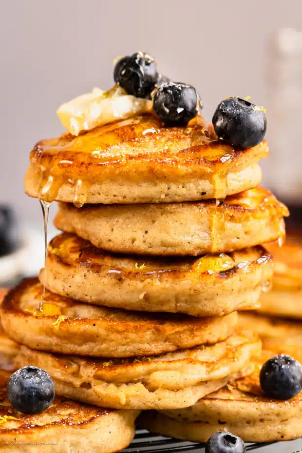 Straight on photo of a stack of pancakes with ricotta cheese.
