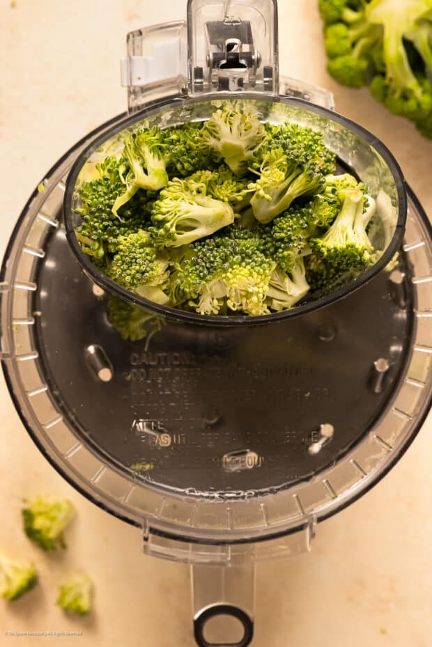 Overhead photo illustrating ricing vegetables with the food processor disk attachment.
