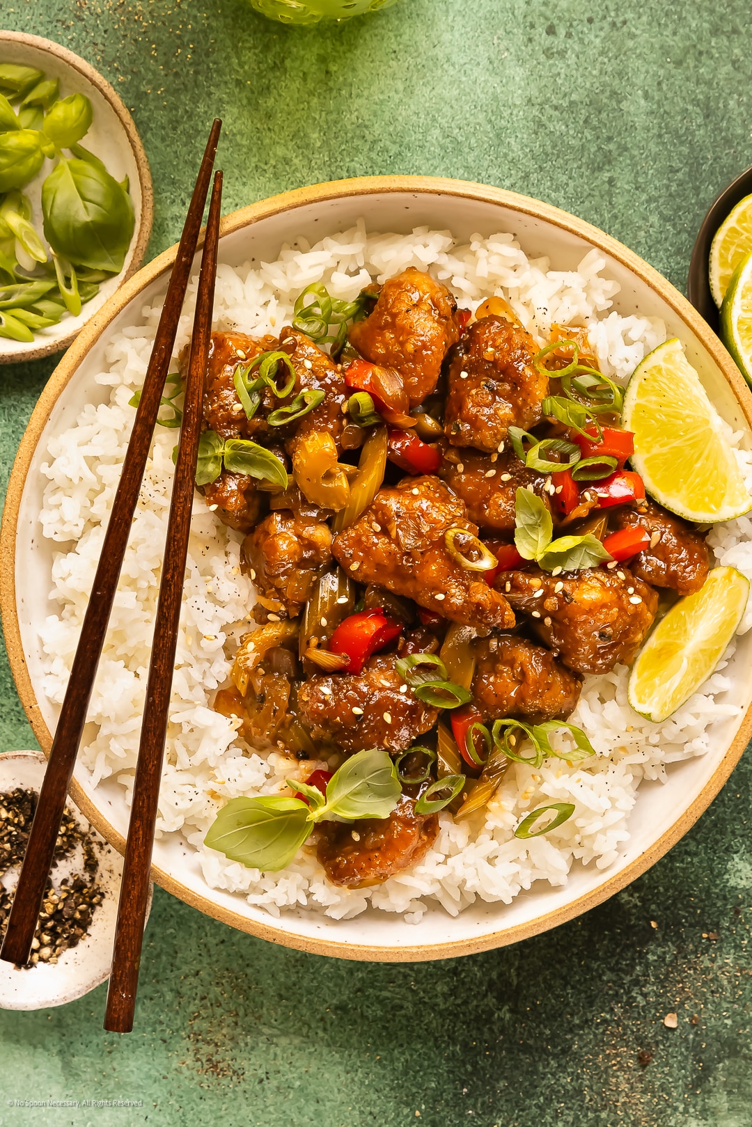 Overhead photo of a bowl of chinese peppered chicken over steamed white rice.