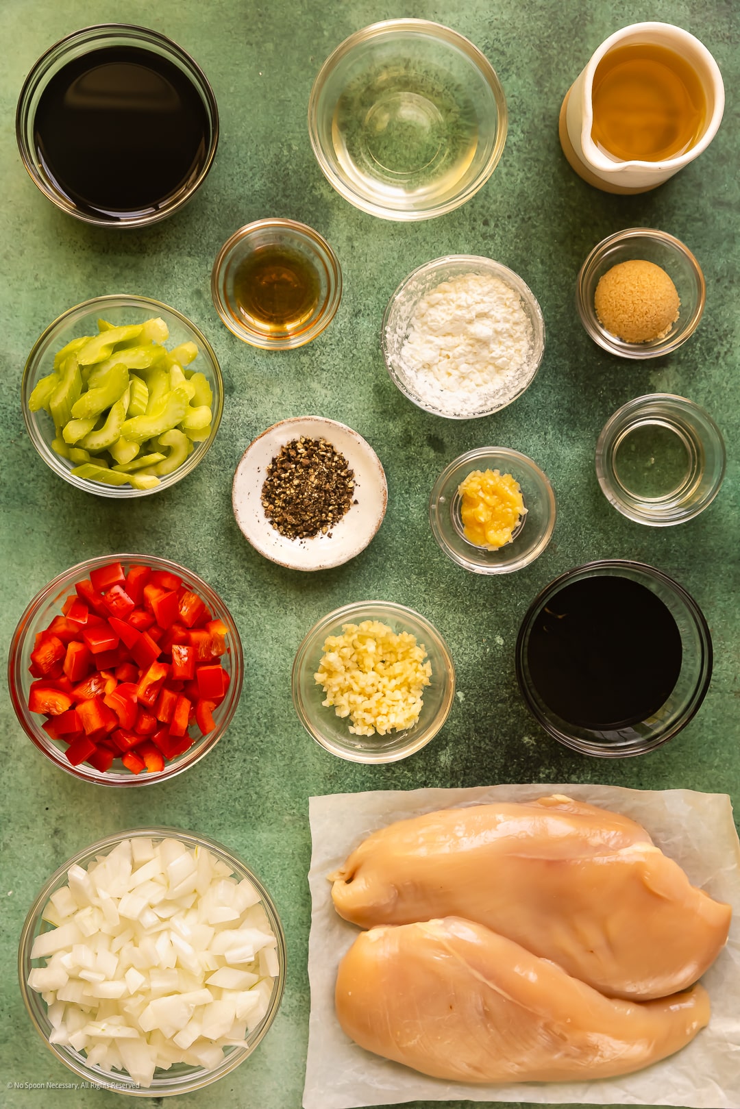 Overhead photo of all the ingredients needed to make crispy black pepper chicken neatly arranged on a kitchen counter.